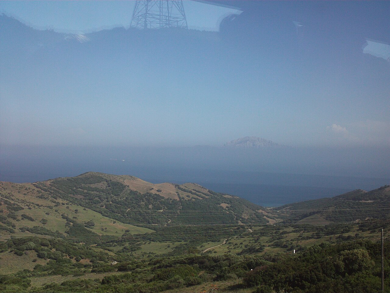 Vista ao nível do mar através do Estreito de Gibraltar: no horizonte, o Jebel Musa, o Pilar de Hércules africano que domina Ceuta.
