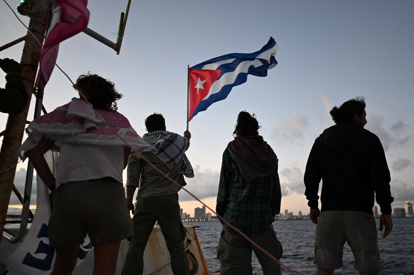 O ativista brasileiro Thiago Ávila acena com uma bandeira cubana a bordo da embarcação Maguro
