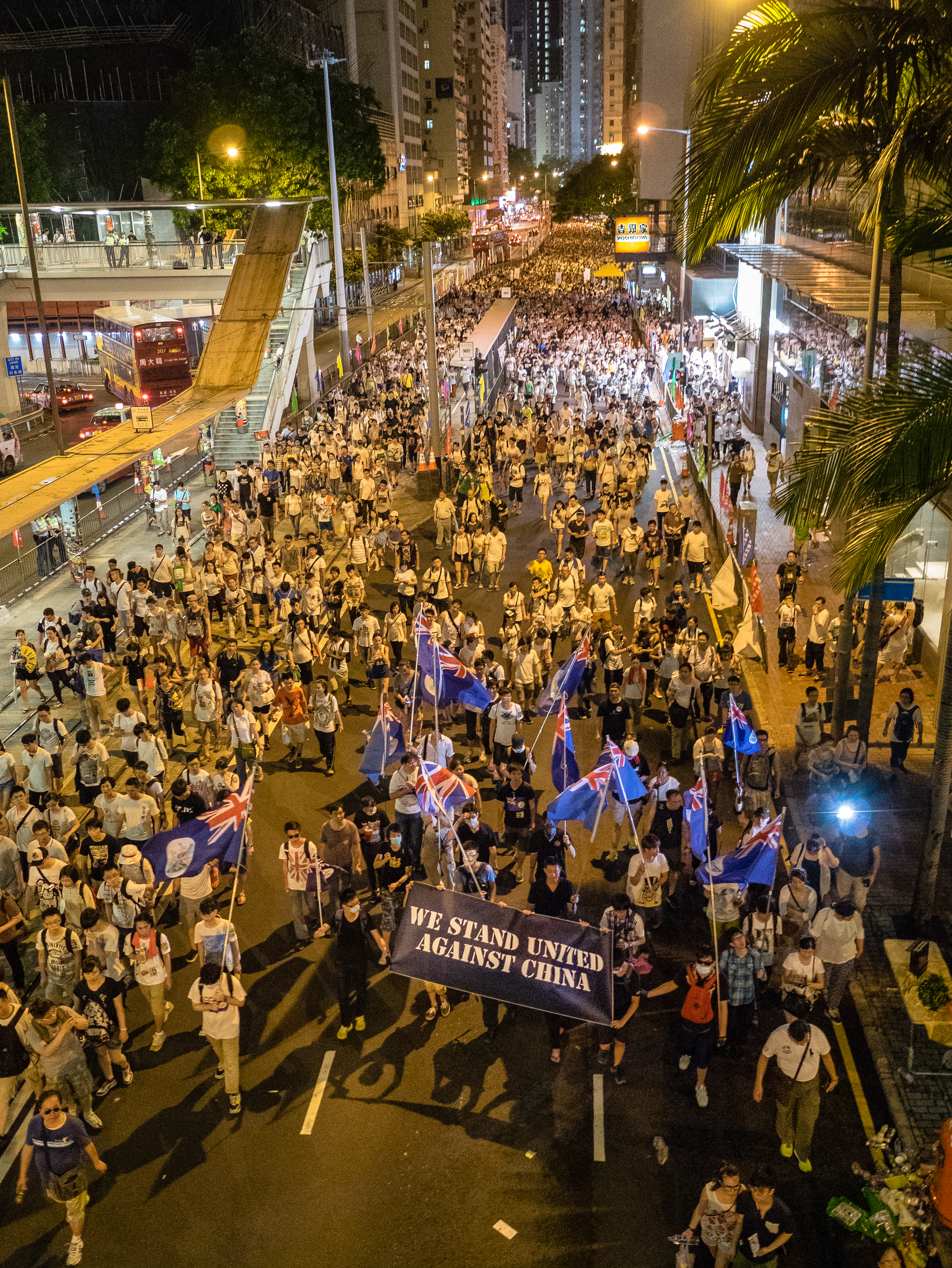 Manifestação de 1º de julho em Hong Kong, cerca de 2014, com cartazes e milhares de pessoas marchando.