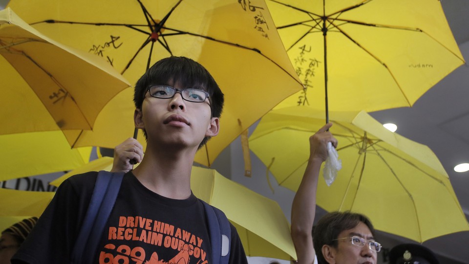 Joshua Wong com guarda-chuvas amarelos.