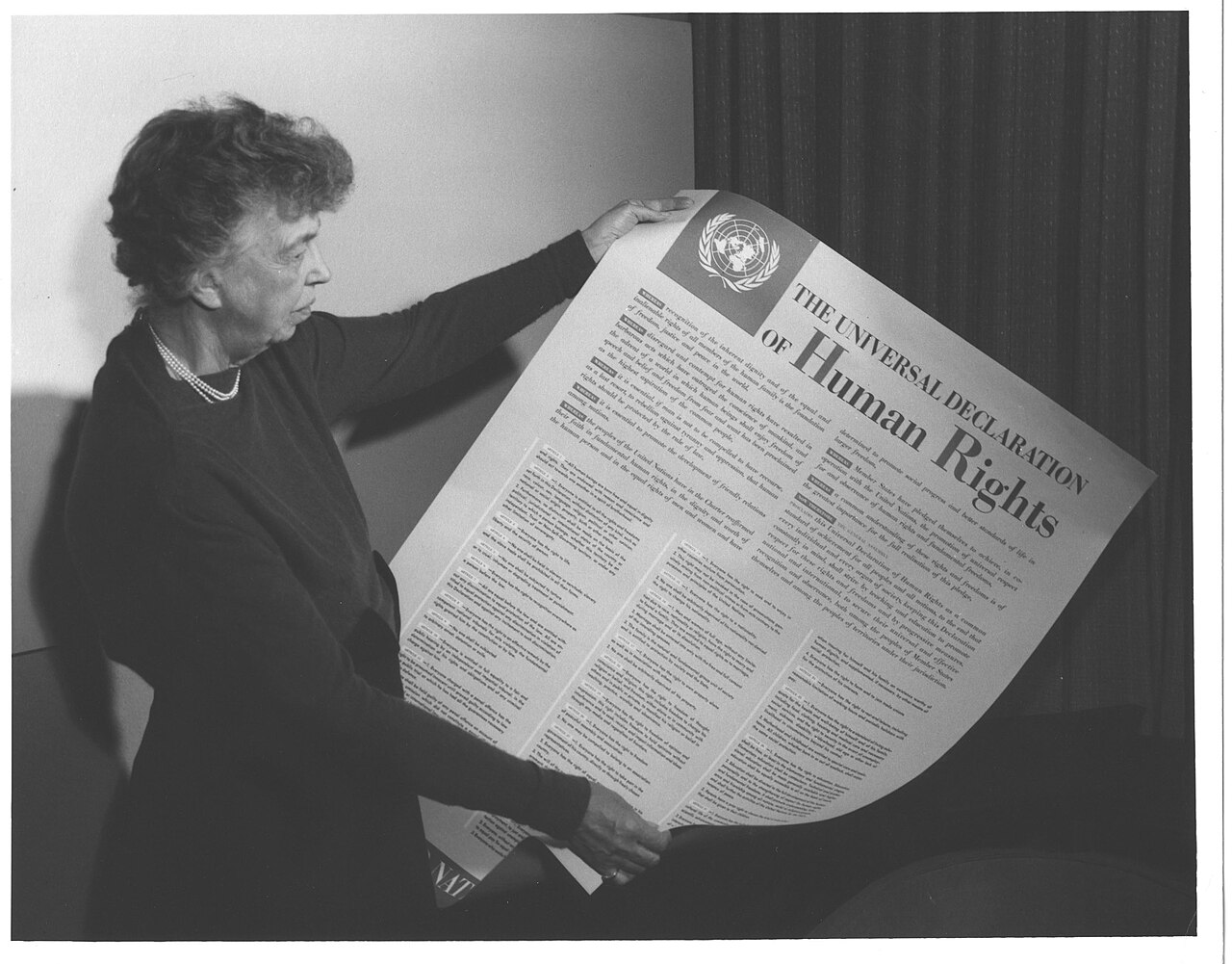 Eleanor Roosevelt segurando o cartaz da Declaração Universal dos Direitos Humanos.