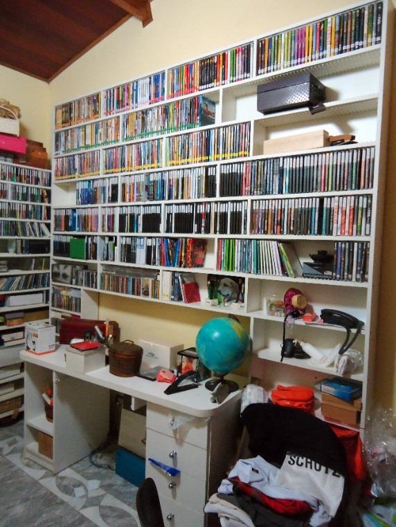 Figura 50 do Laudo 0392/2016 da Polícia Federal — Imagem do Dormitório/escritório com detalhe para a prateleira com o acervo de CDs e DVDs.