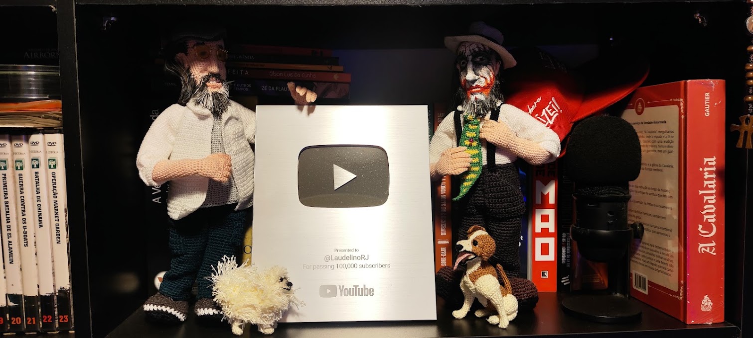 Placa de Prata do YouTube entregue a @LaudelinoRJ por ultrapassar 100 mil inscritos, ladeada pelos bonecos de croch&ecirc; do Laudelino